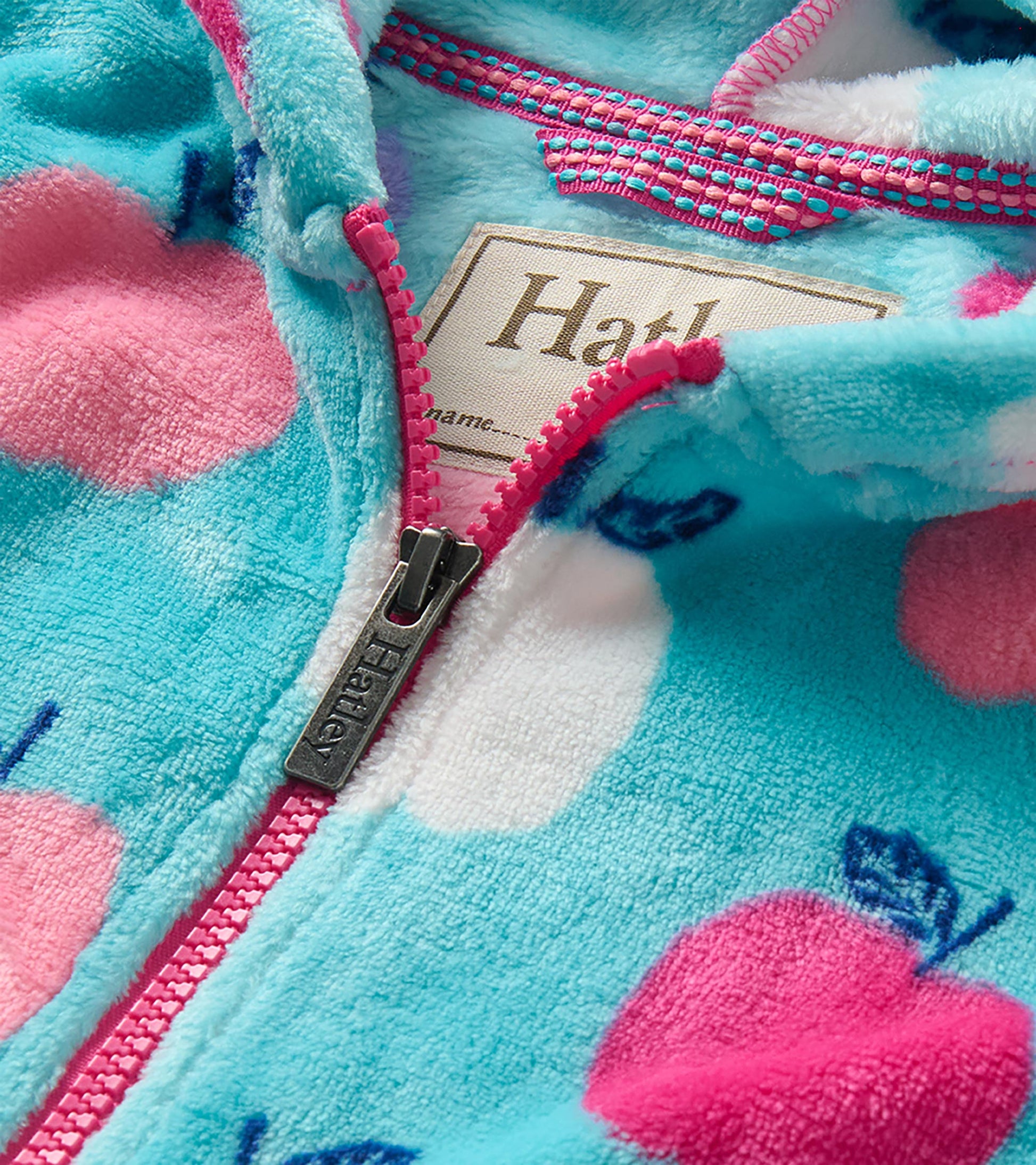 Close-up of aqua apple print hoodie with bright pink zipper and visible Hatley zipper pull