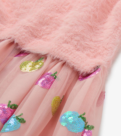 Close-up of pink fuzzy knit bodice and tulle skirt with multicolored sequin apple motifs