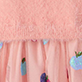 Pink ruffled fabric with small hanging tassels in blue and purple