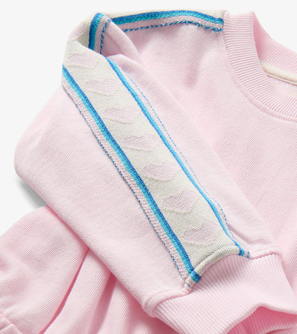 Close-up of pink sweatshirt dress shoulder with blue and white striped trim and ribbed neckline