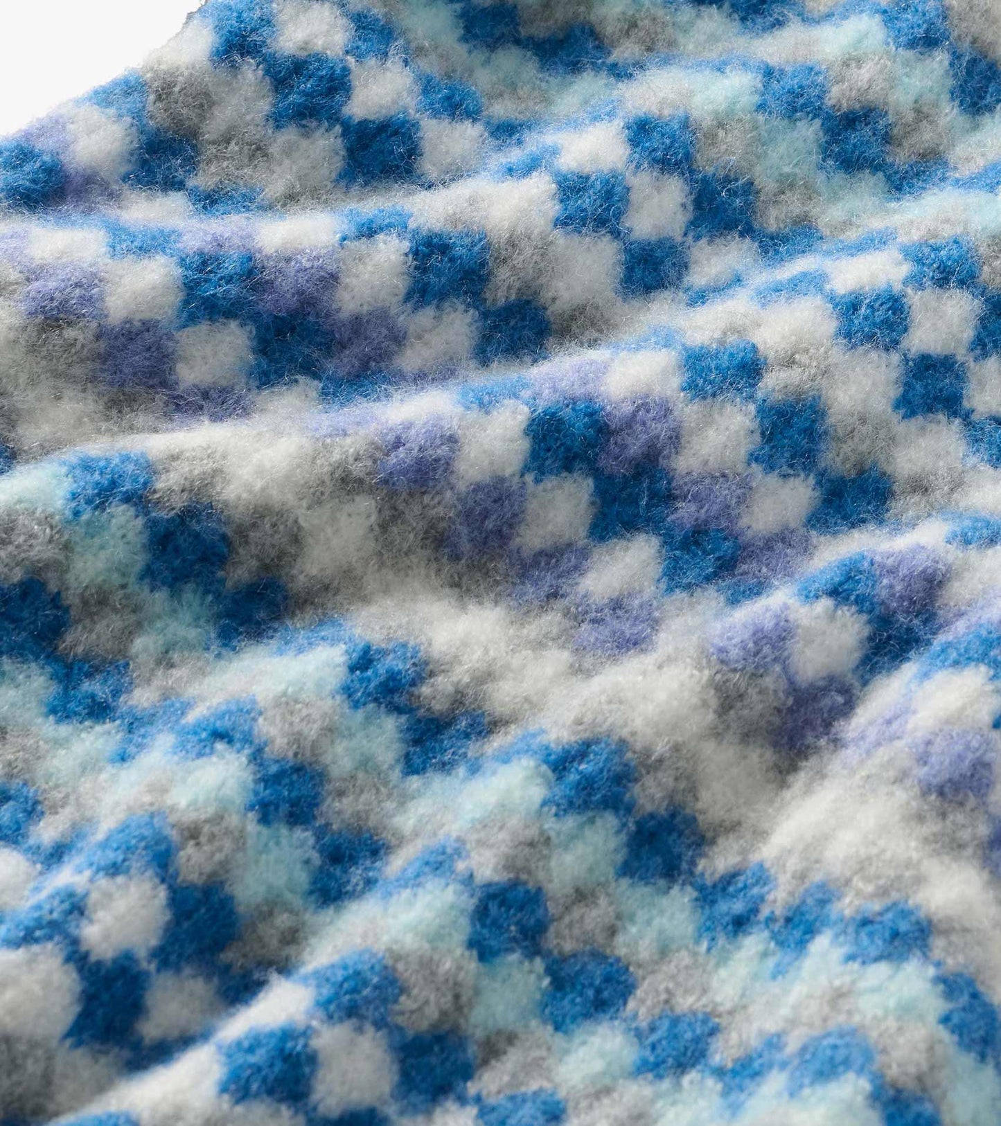 Close-up of the sweater's fuzzy blue, white, gray, and lavender ombre knit pattern
