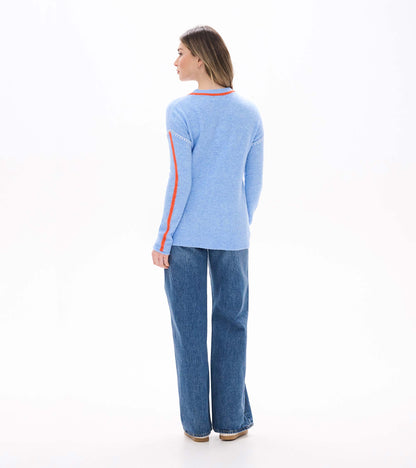 Back view of azure blue Maeve sweater with orange sleeve stripes and white shoulder stitching