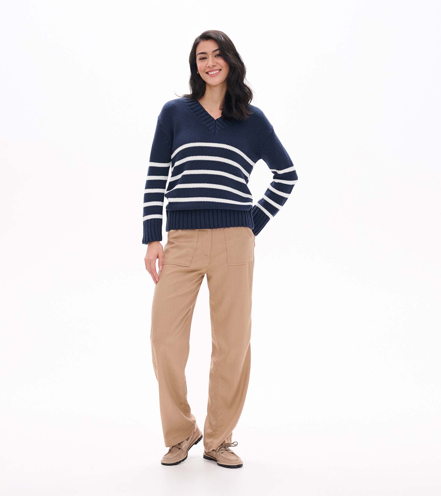 Full front view of navy V-neck sweater with cream stripes on model