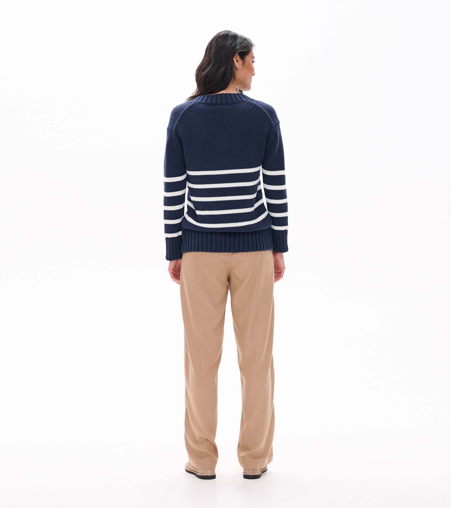 Back view of navy sweater with cream stripes across the lower back and sleeves on model