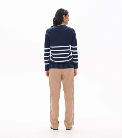 Back view of navy sweater with cream stripes across the lower back and sleeves on model
