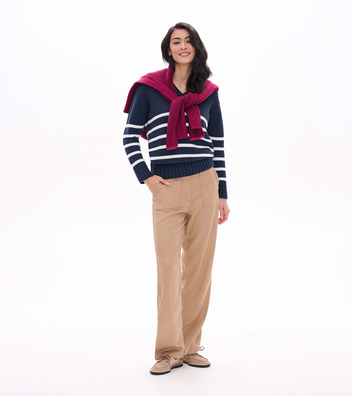 Model wearing a navy V-neck sweater with cream stripes and ribbed hem, shown from the front