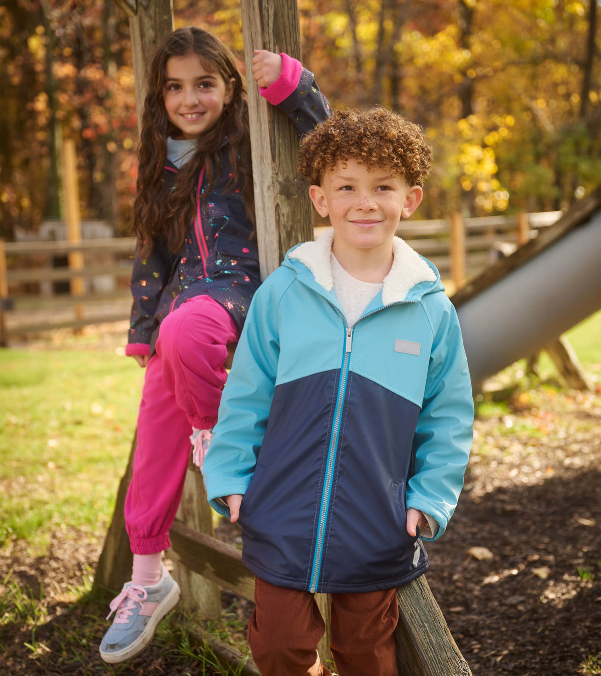 Boy wearing blue colourblock sherpa-lined rain jacket outdoors, front view with hood and zip closure
