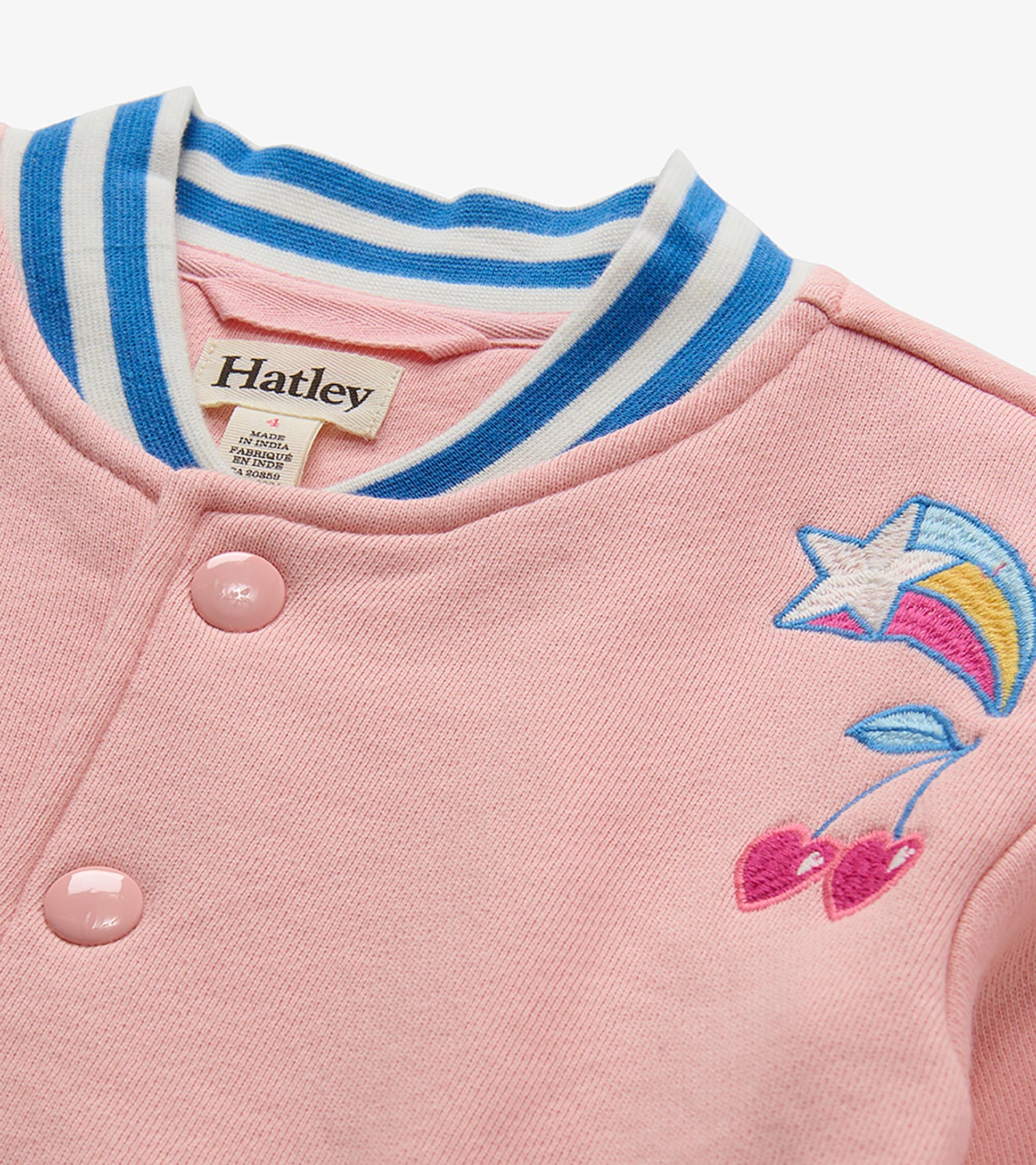 Close-up of pink bomber jacket collar with blue and white stripes and shooting star and cherry embroidery