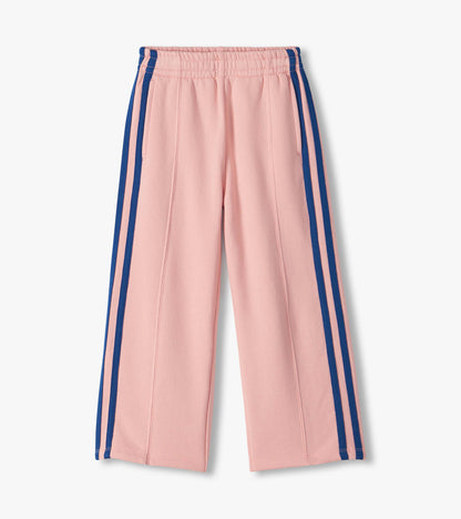 Front view of girls pink wide leg track pants with elastic waistband, side pockets, and blue side stripes