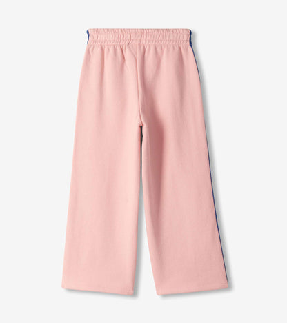 Back view of girls pink wide leg track pants with elastic waistband and blue side stripes