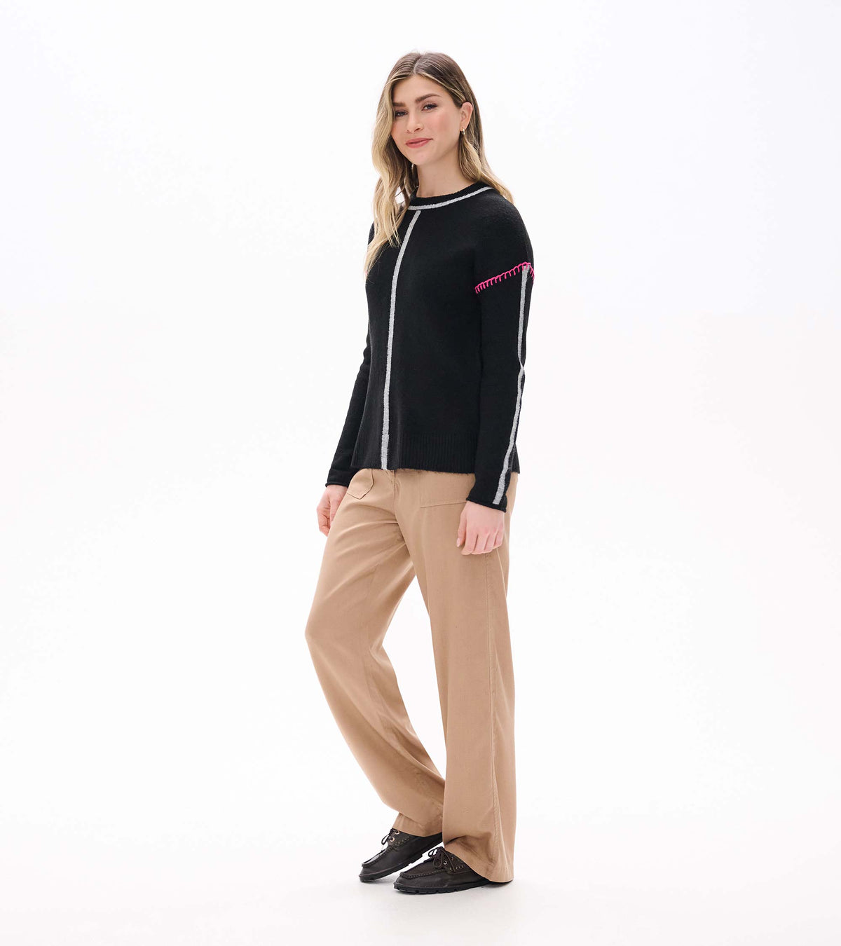 Three-quarter front view of black sweater with grey stripe details and pink stitching at the shoulders