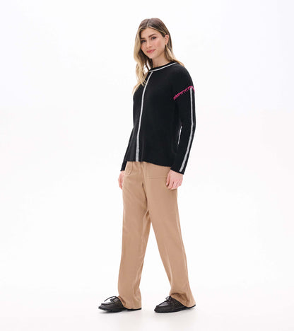 Side front view of black sweater with grey center and sleeve stripes and pink shoulder stitching