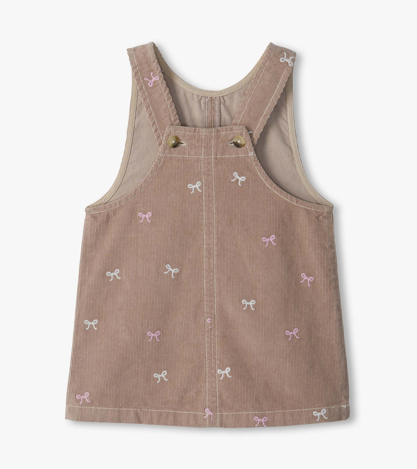 Back view of pink cord pinafore dress with crossed straps and embroidered bow pattern