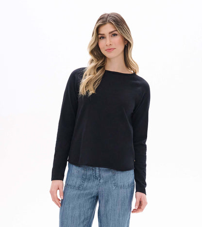 Front view of black raglan sleeve tee with long sleeves and a curved hem on model