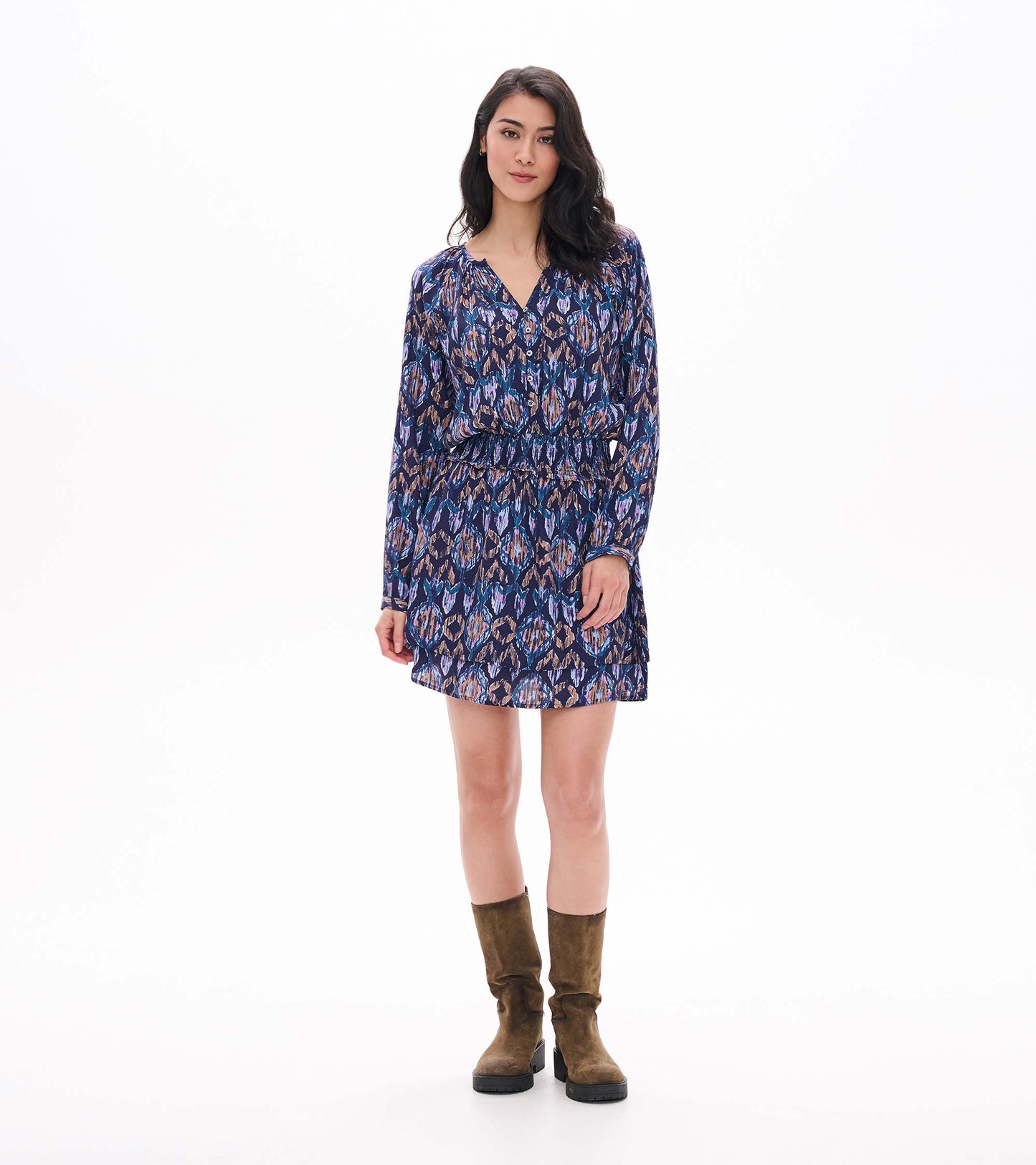 Front view of smocked waist mini dress with long sleeves, buttoned V-neck, and blue textured ikat print