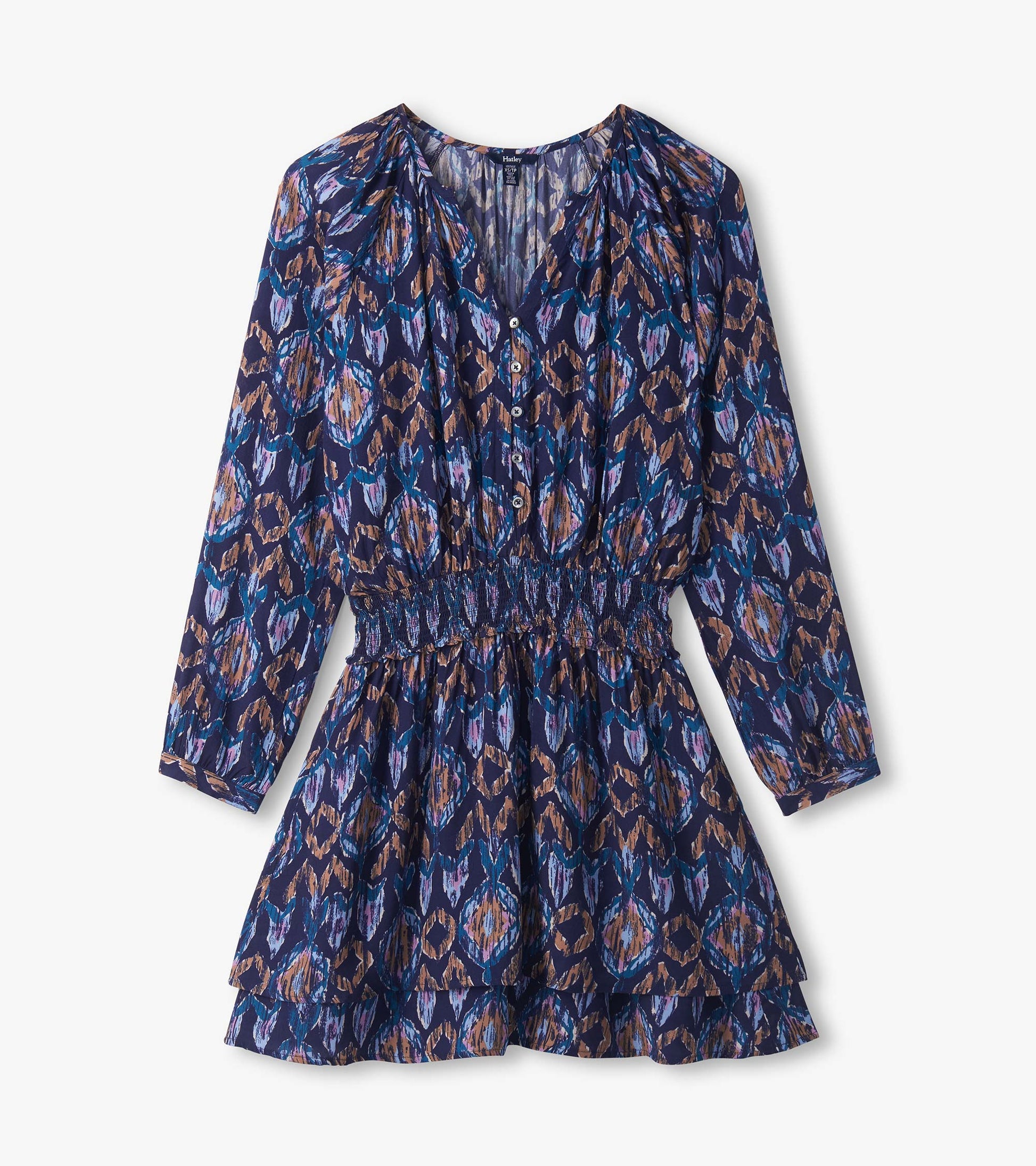 Close-up of blue textured ikat dress with buttoned V-neck, long sleeves, smocked waist, and tiered skirt