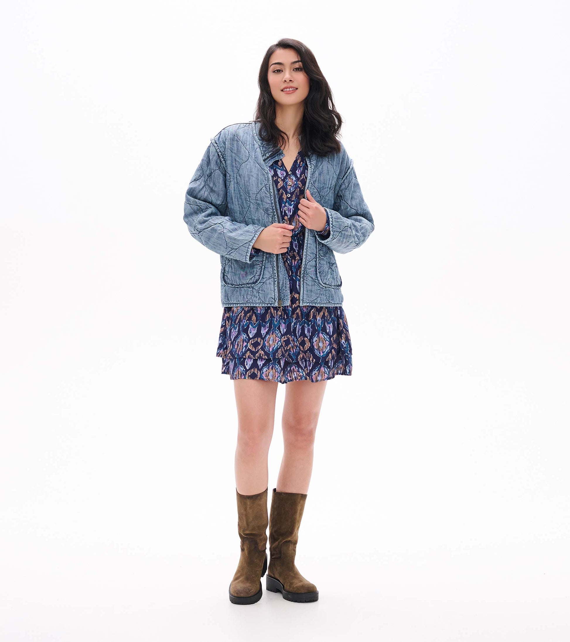 Front view of navy textured ikat mini dress with button placket, layered skirt, and smocked waist under a blue jacket