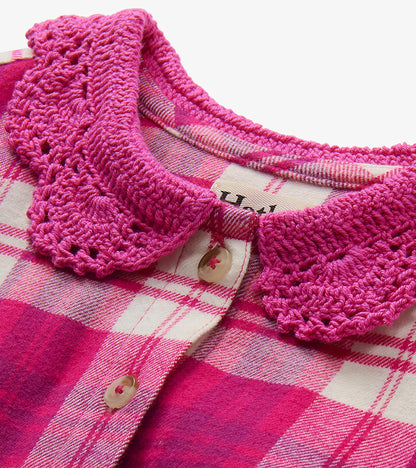 Close-up of bright pink crocheted collar and button placket on pink plaid dress