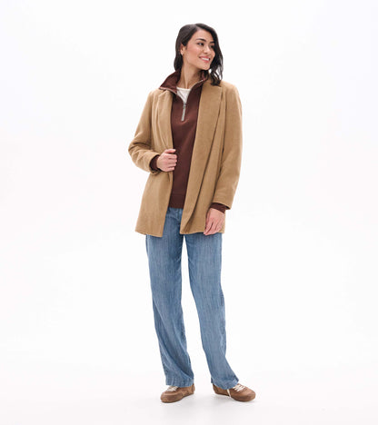 Brown 1/4 zip top layered under a camel coat, showing the high collar and front zipper