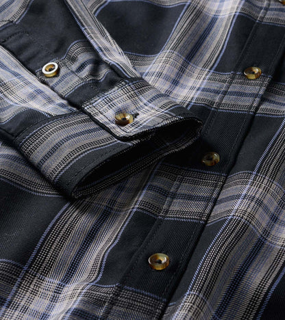 Close-up of black and tan plaid shirt dress showing button-front placket and collar detail