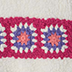 Two crocheted square motifs in pink, blue, and white on a light background
