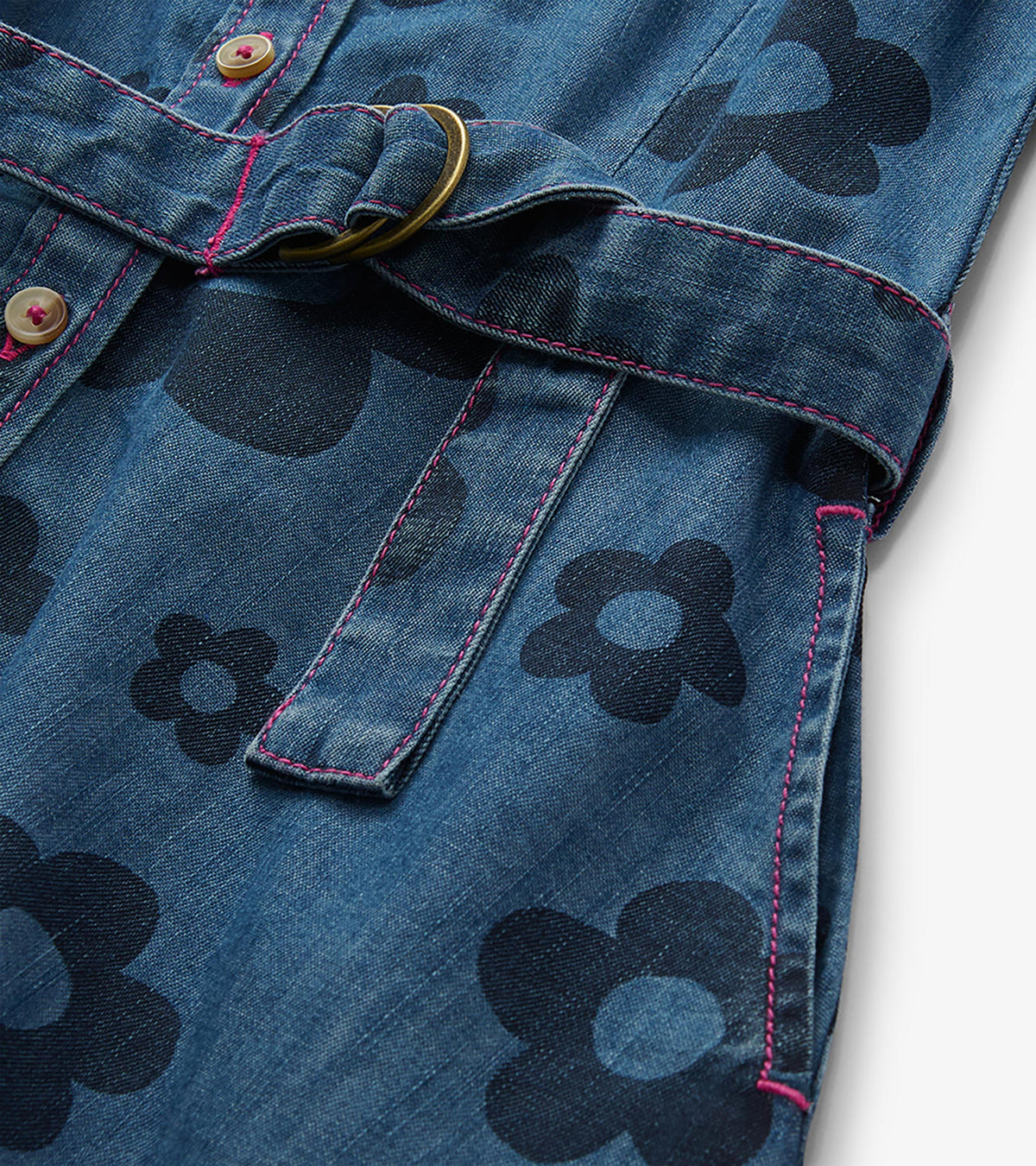 Close-up of blue jean dress with large flower print, pink stitching, buttons, and tie belt with ring detail