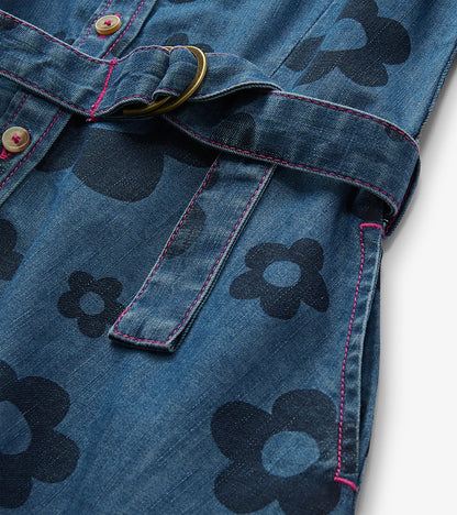 Close-up of blue jean dress with large flower print, pink stitching, buttons, and tie belt with ring detail