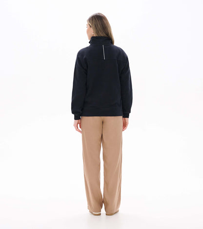 Back view of black knit top with stand collar, long sleeves, and a vertical white detail at the upper back