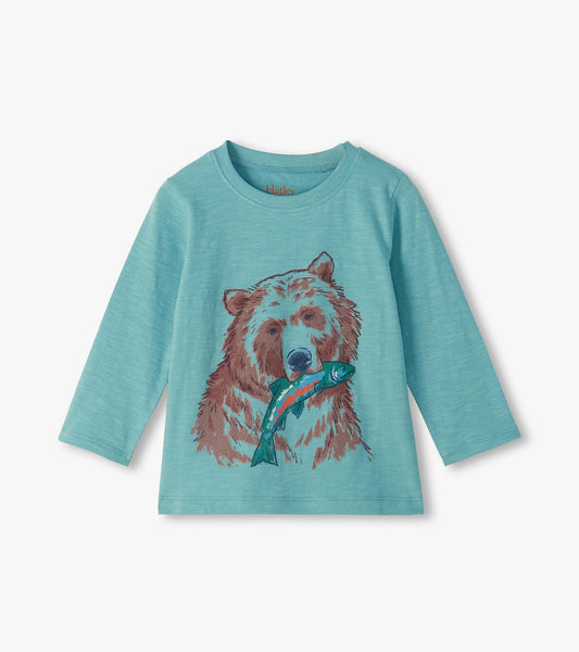 Turquoise long sleeve crew neck tee with a brown grizzly bear graphic holding a blue fish on the front