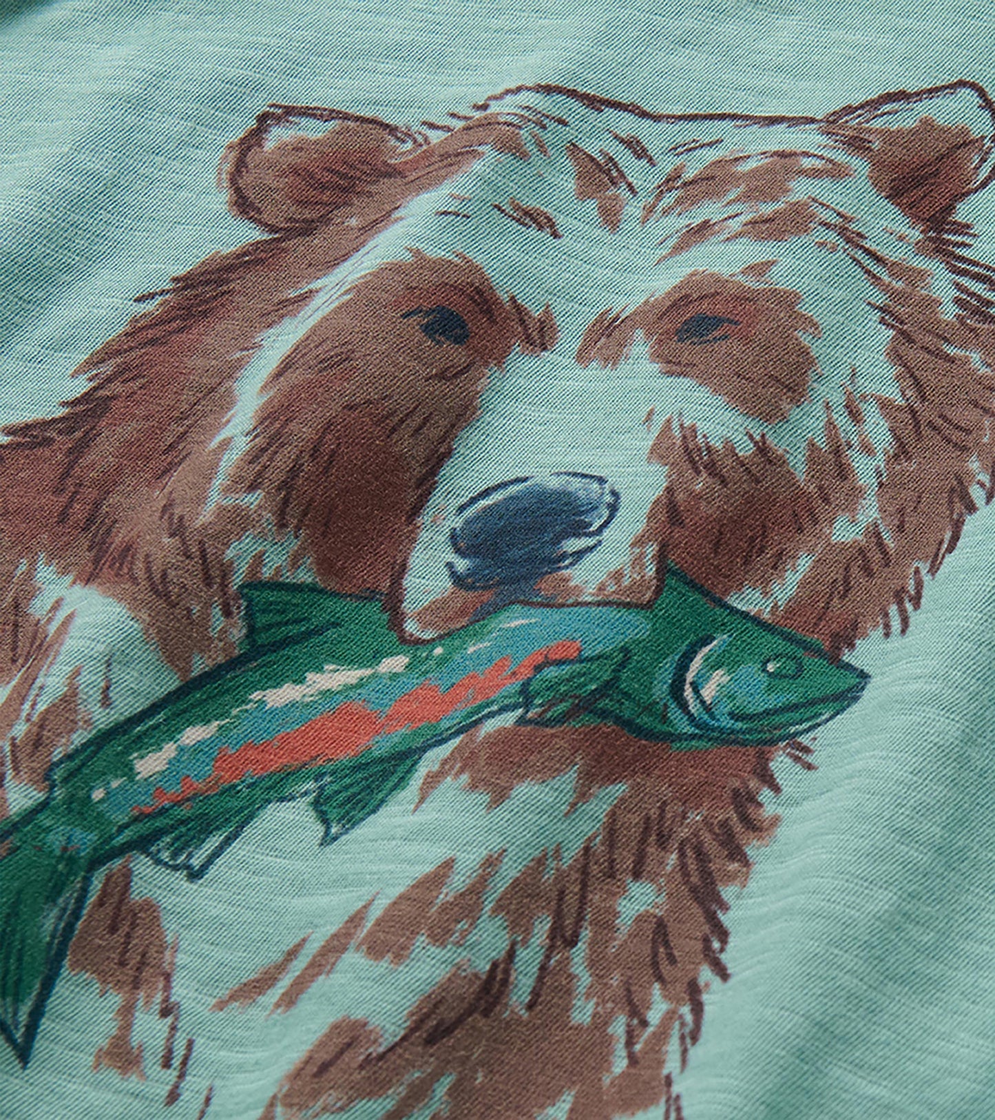 Close-up of the grizzly bear and green fish graphic on the aqua toddler T-shirt