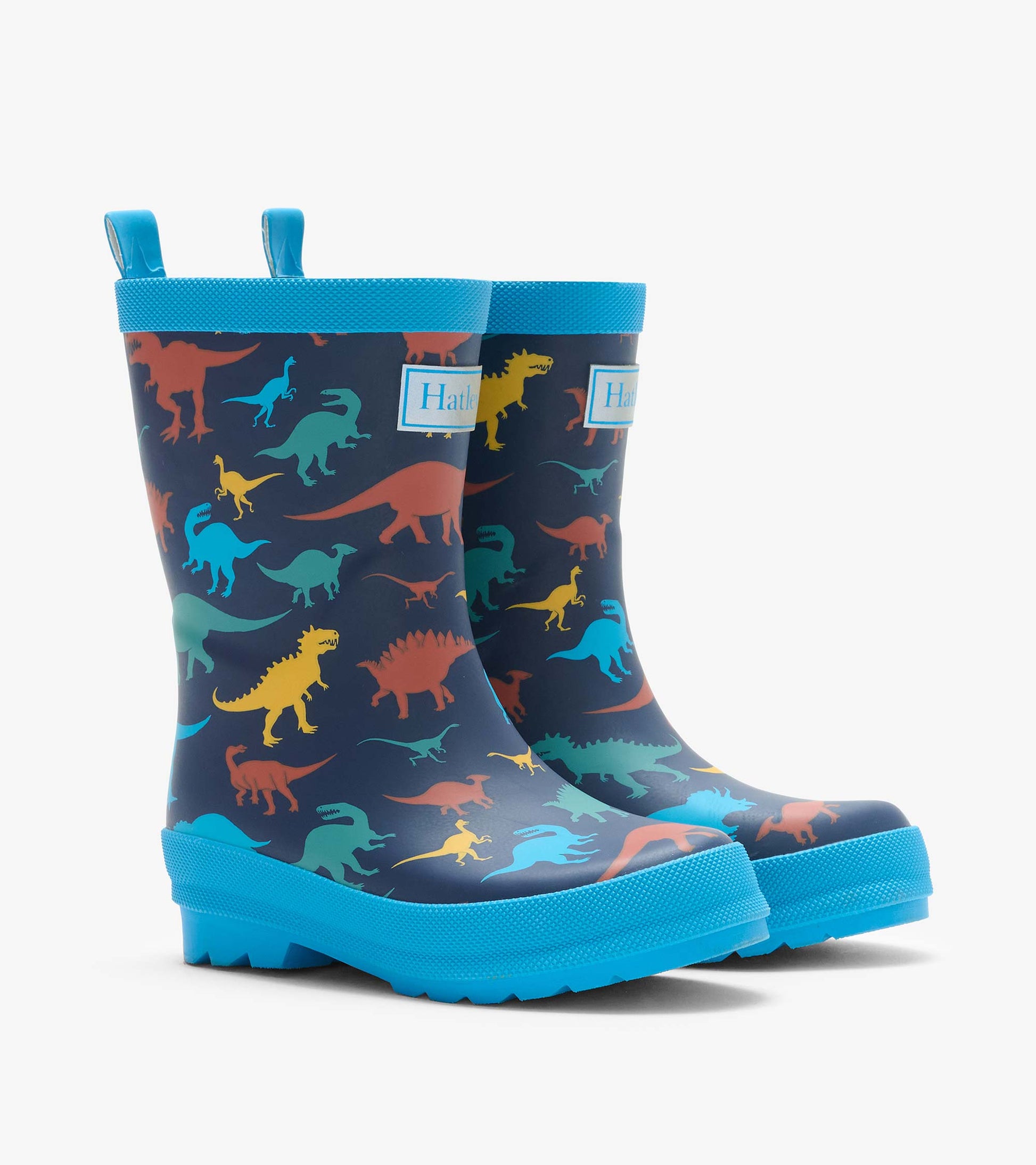 Pair of navy rain boots with colorful dinosaur print, bright blue trim, and Hatley logo patch