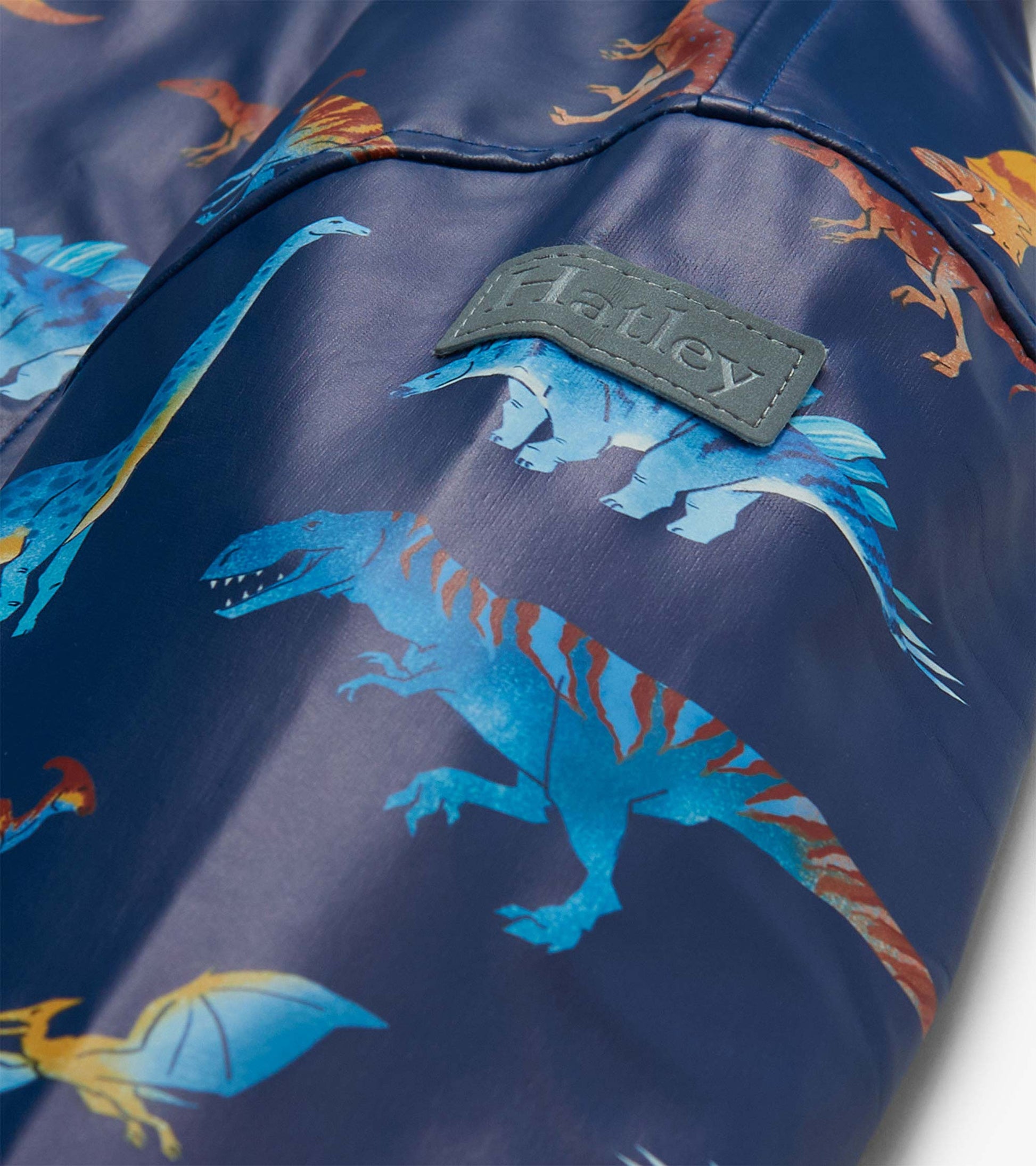 Close-up of sleeve with colorful dinosaur print and raised Hatley logo tab