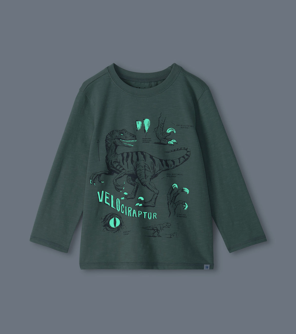 Green boys long-sleeve T-shirt with glow-in-the-dark velociraptor graphic shown in low light