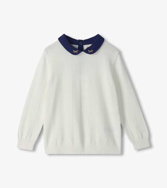 Cream sweater with long sleeves and a navy Peter Pan collar with small embroidered bows
