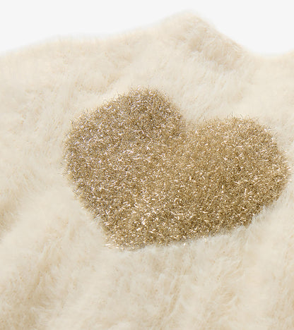 Close-up of glittery gold heart detail on cream fuzzy knit cardigan