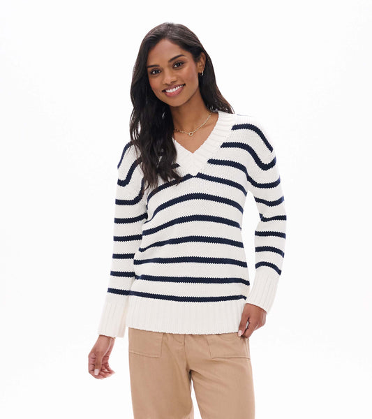 Model wearing cream V-neck sweater with navy horizontal stripes and ribbed hem