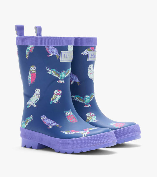Pair of navy kids rain boots with colorful owl print and lavender trim, shown from the front angle