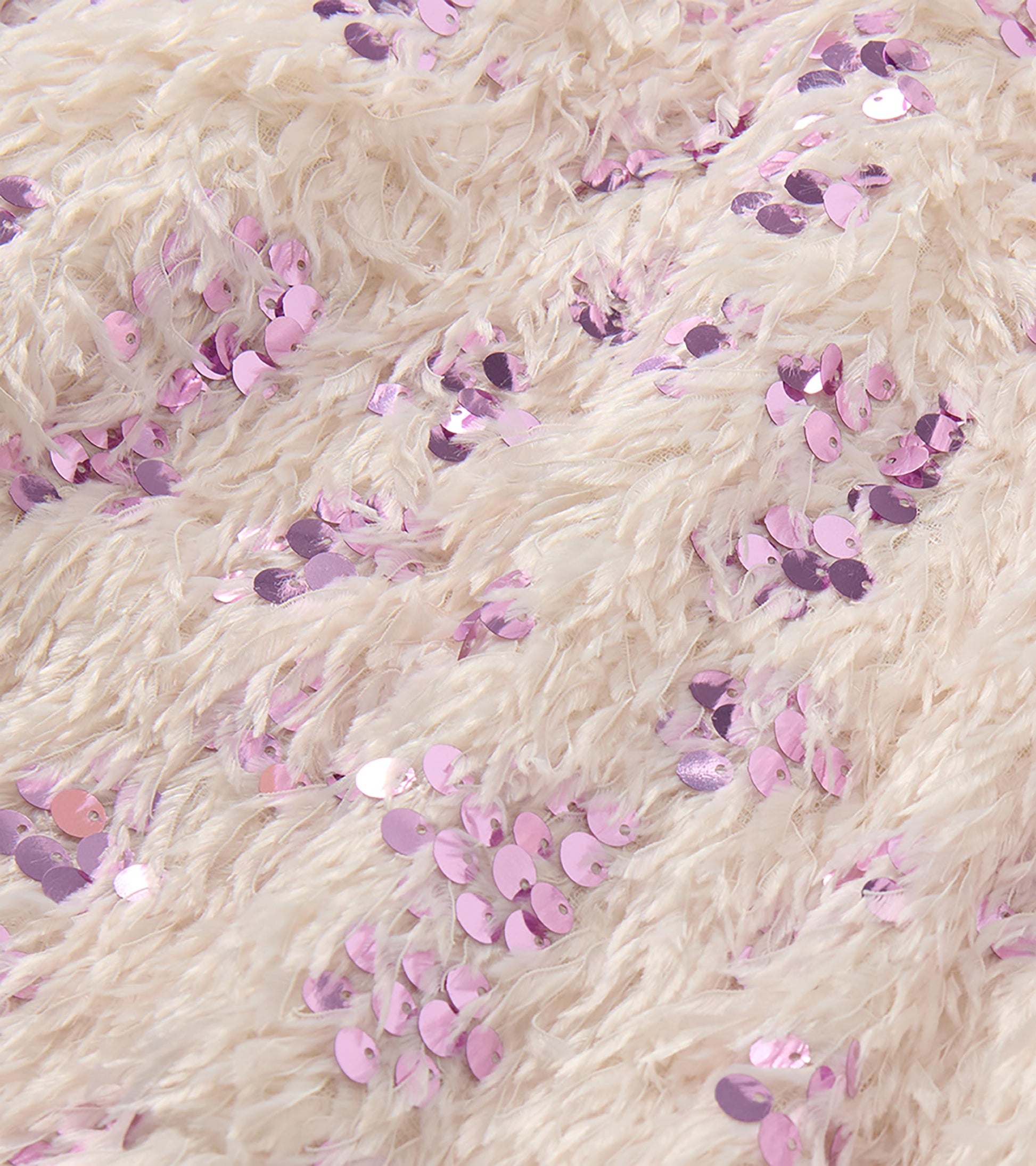 Close-up of cream feather-textured fabric with scattered pink sequins