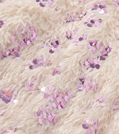 Close-up of cream feather-textured fabric with scattered pink sequins