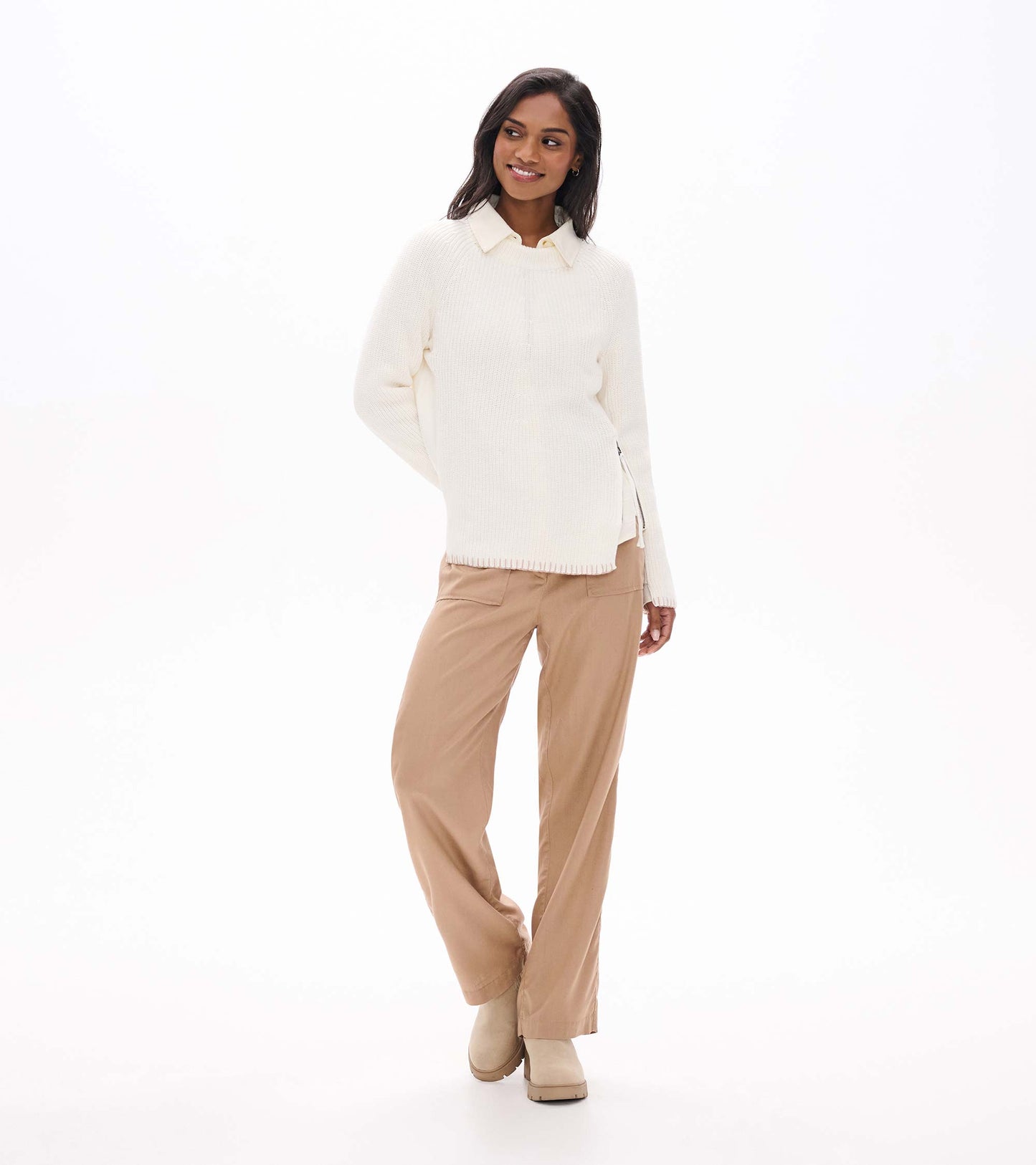Front view of cream raglan sweater styled over a collared shirt with side zip detail