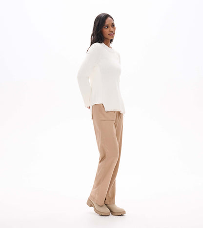 Side view of cream raglan sweater showing the side zip opening and split hem