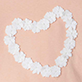 Heart shape made of white flowers on a peach background