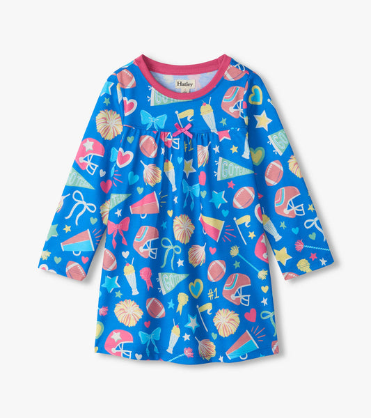 Kids blue nightdress with pink trim and cheer print featuring helmets, footballs, pom-poms, bows, and stars