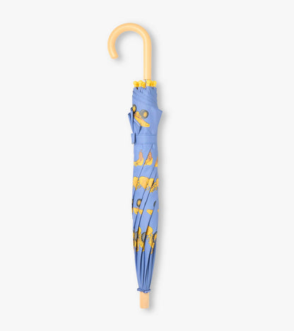 Closed blue umbrella with yellow construction truck print and curved beige handle