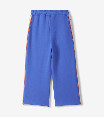 Back view of girls blue wide leg track pants with pink star side stripes