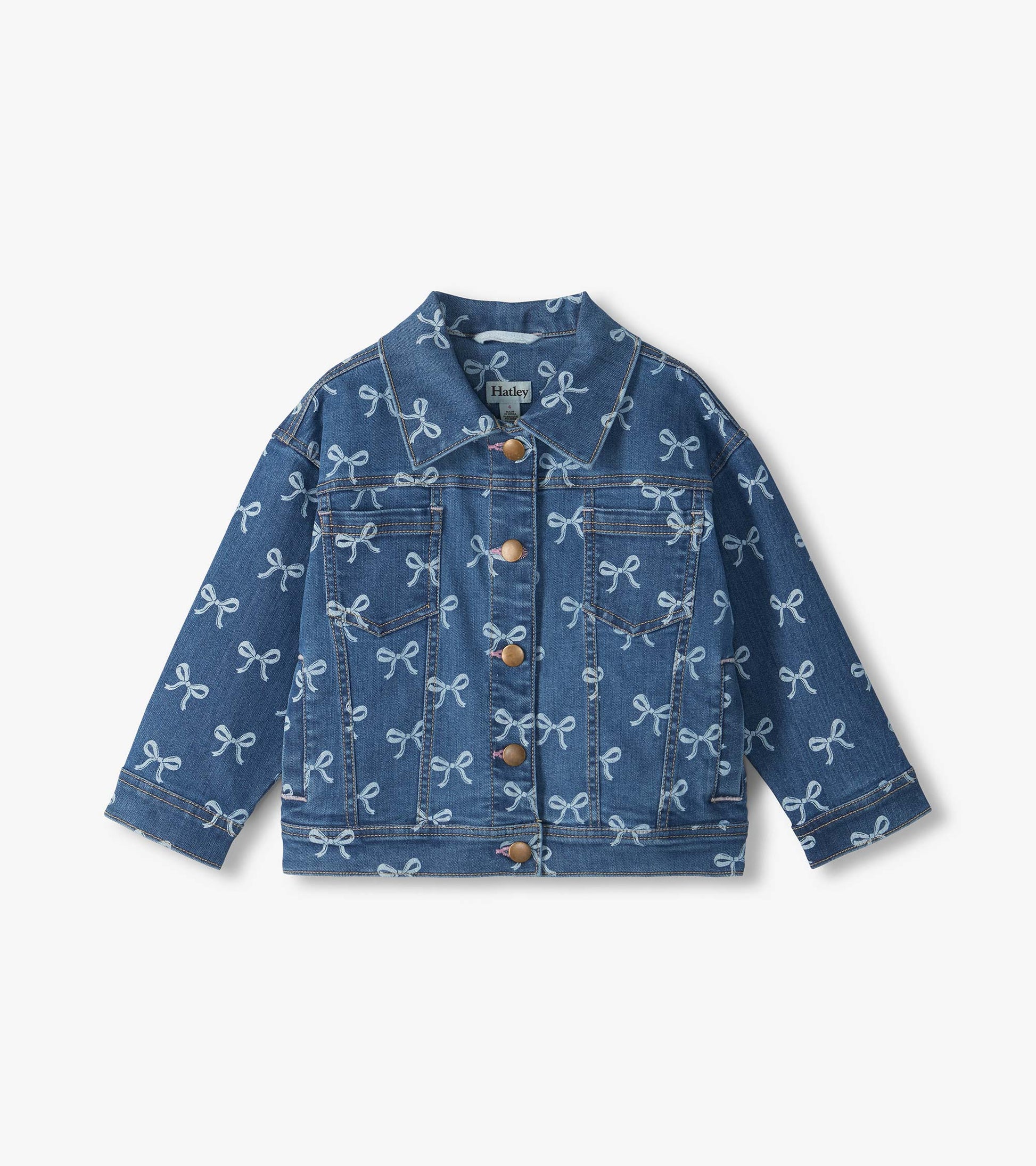 Front view of blue slouchy denim jacket with allover bow print, pointed collar, chest pockets and button front