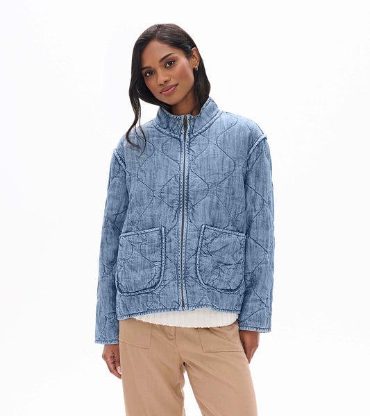 Front view of blue acid rinse quilted jacket with stand collar, zip front, and two patch pockets