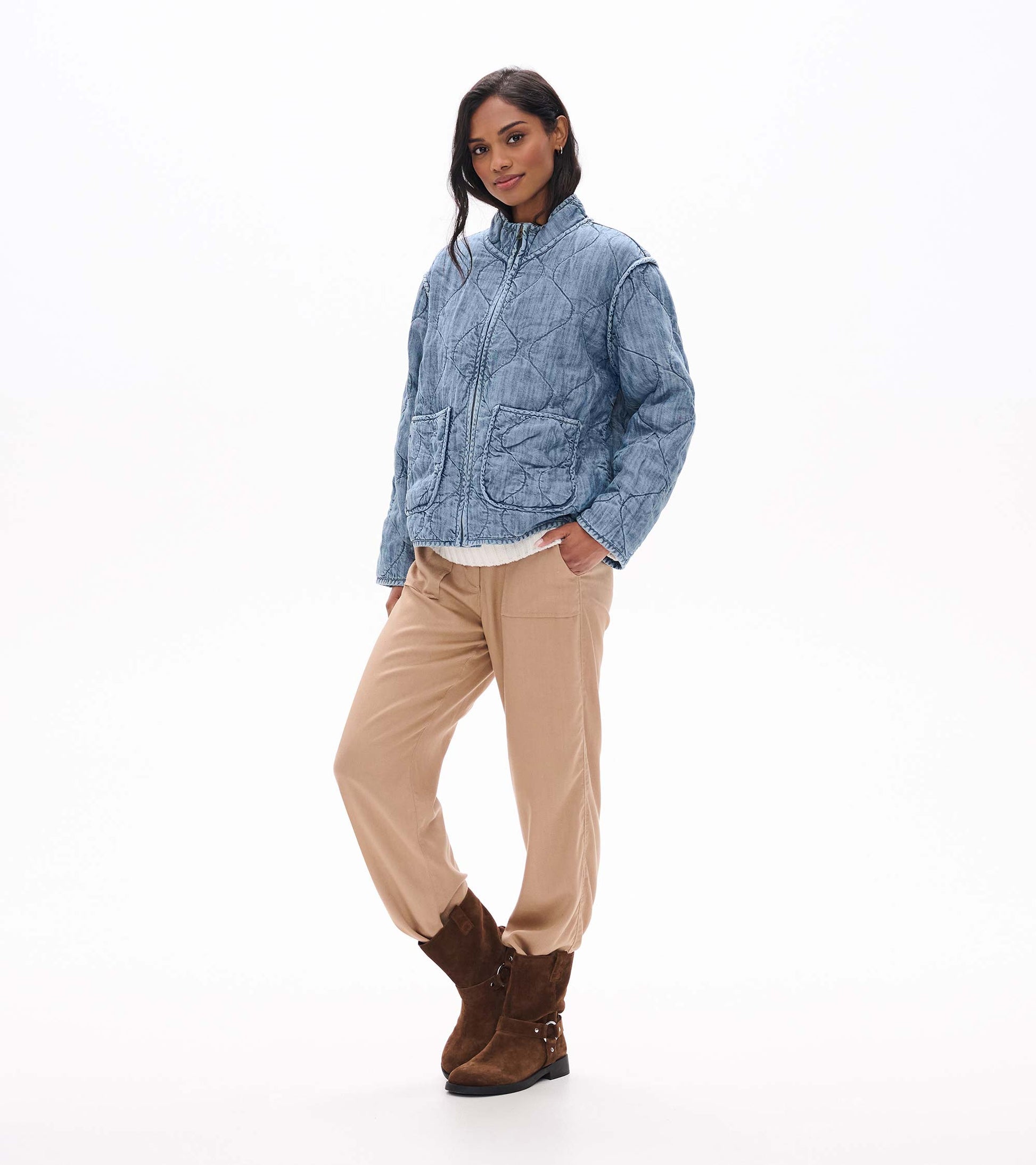Three-quarter front view of blue acid rinse quilted jacket with stand collar and patch pockets