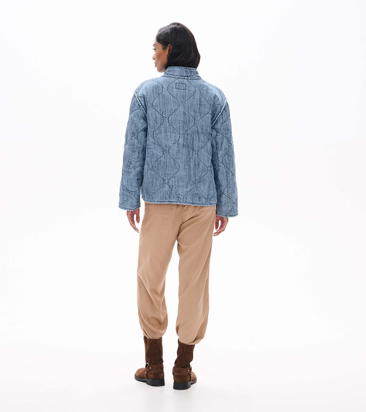 Back view of blue acid rinse quilted jacket with curved quilted pattern and stand collar