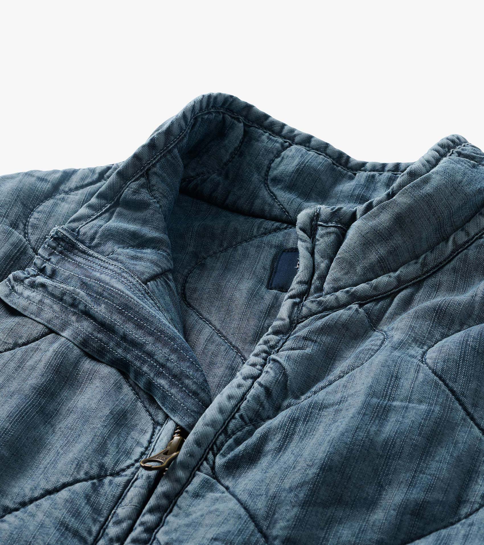 Close-up of blue acid rinse quilted jacket collar and zipper detail